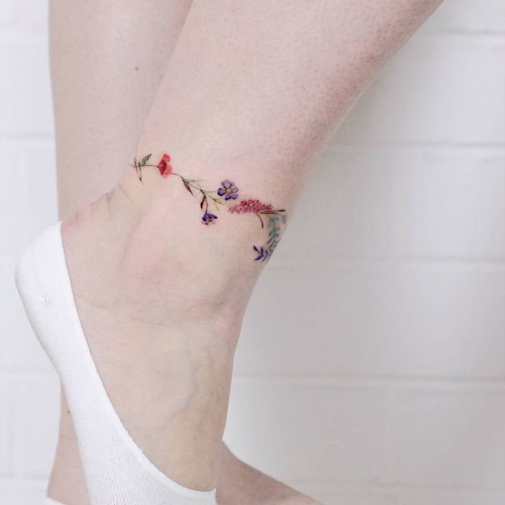 As tatuagens mais bonitas e delicadas para tornozelos Buquê colorido de pequenas flores violetas vermelhas