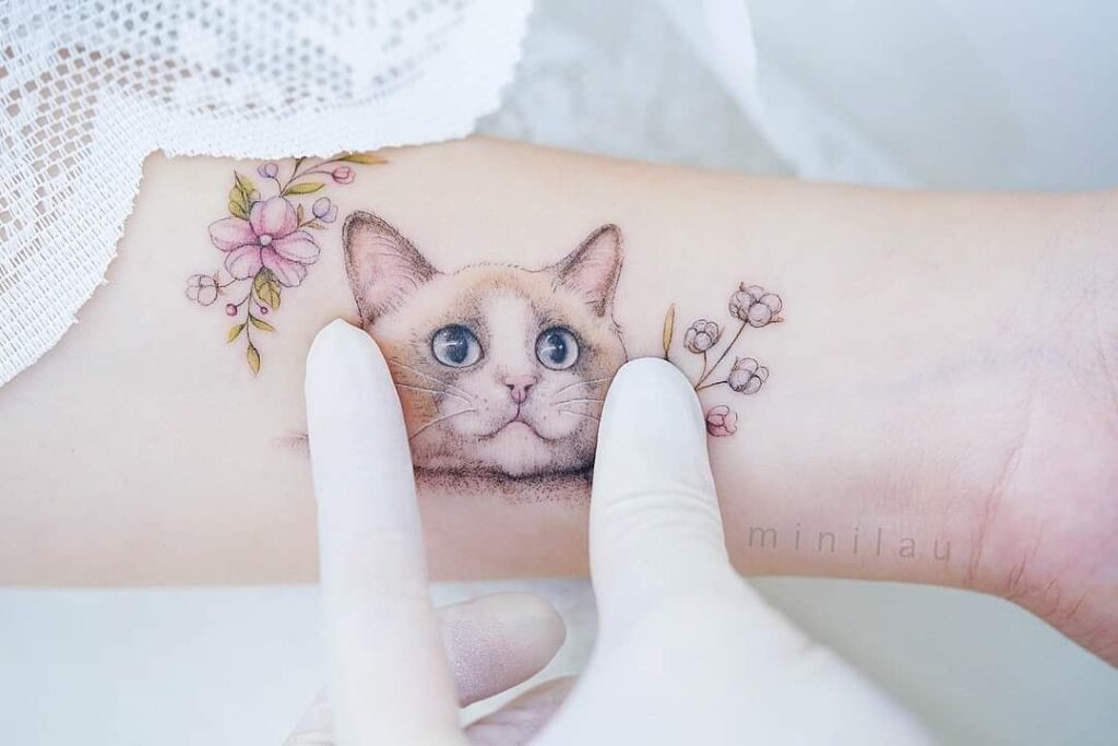 I migliori tatuaggi per gatti faccia di gatto occhi azzurri sull'avambraccio