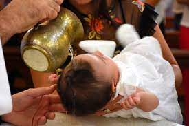 Les parrains ne sont pas choisis pour les cadeaux lorsque le prêtre verse de l'eau bénite sur le bébé à partir d'un pichet doré