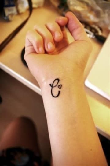 Tatuaje Letra C con corazon pequeno en muneca