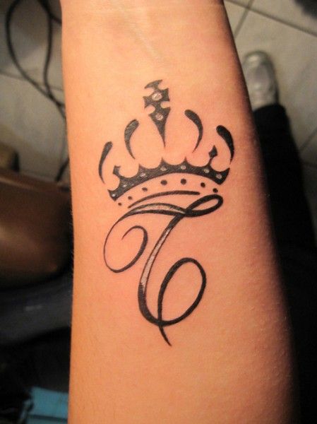 Letra C com tatuagem de coroa no braço