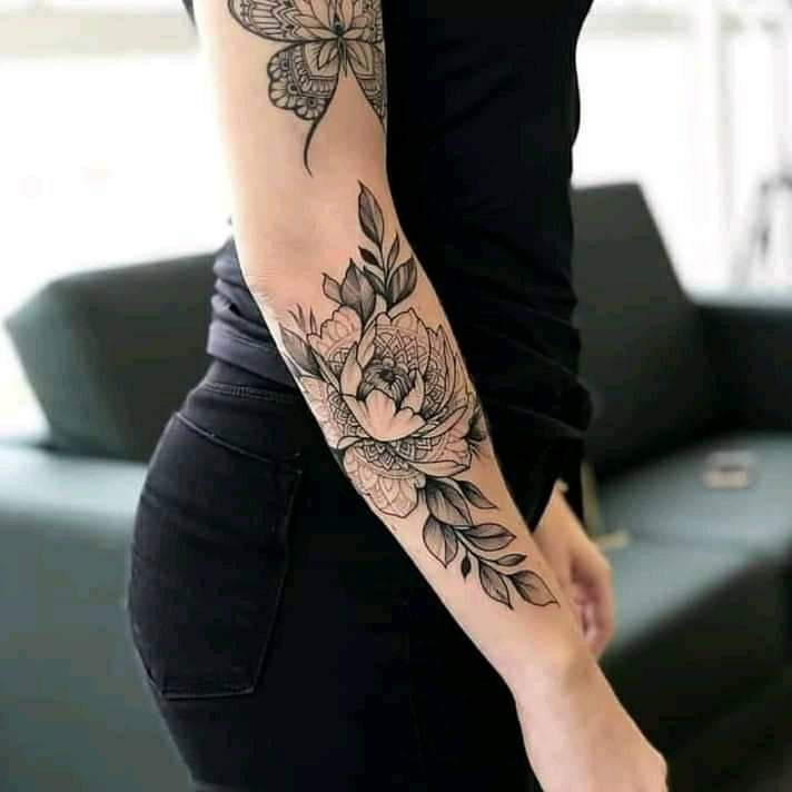 Blumenzweige und Schmetterlingsärmel-Tattoo auf dem Arm BlackWork