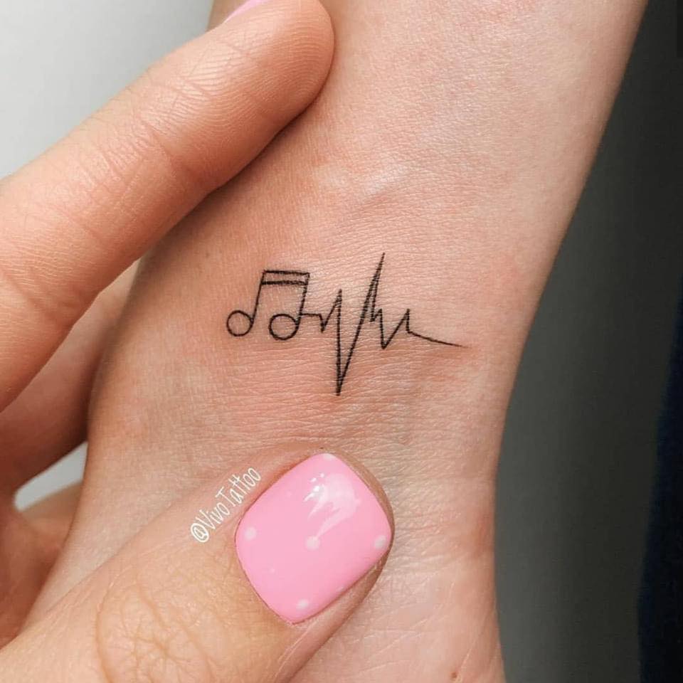 Kleines Cardio- und Musiknoten-Tattoo am Handgelenk