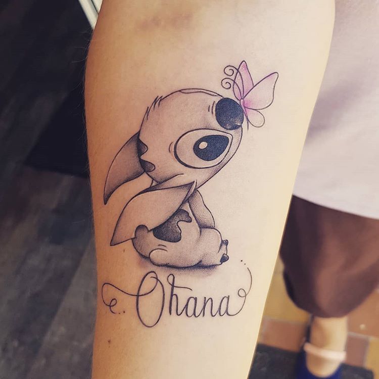 Delicato tatuaggio Stitch Ohana sul braccio con farfalla