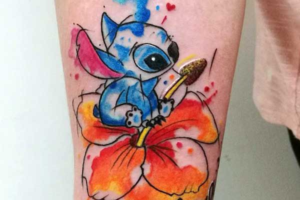 Tatuaje Stitch Ohana sentado en una flor naranja