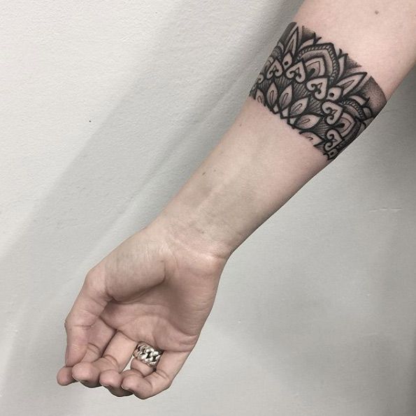 Tätowierung einer Armbinde oder eines Armbands. Mitteldicker Streifen mit Blumenmustern