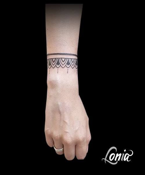 Tatuaje de Brazalete o Pulsera Tipo Tribal con adornos y una linea delgada