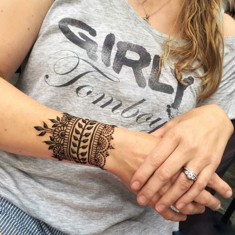 Tätowierung einer Armbinde oder eines Armbands mit Henna-Blumen und Zweiggeflechten