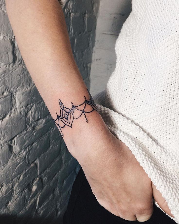 Bracciale o braccialetto tatuaggio sugli ornamenti del polso e mezzo fiore di loto
