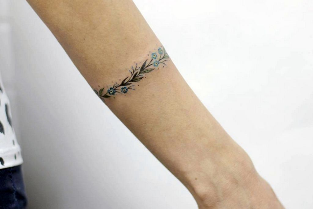 Pulseira fina ou tatuagem de pulseira com galhos e flores azuis claras