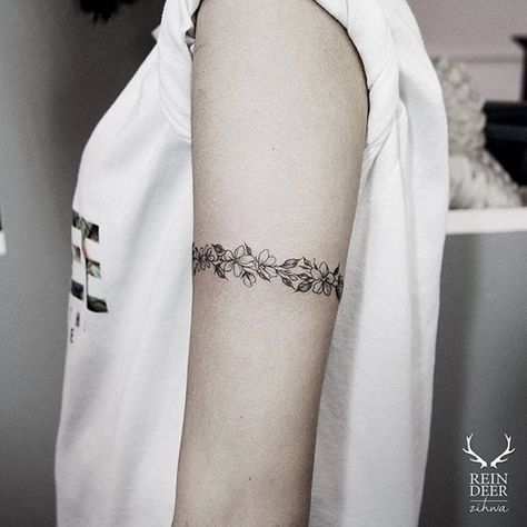 Tatuaggio con fascia da braccio o braccialetto sottile con protezione floreale sul braccio