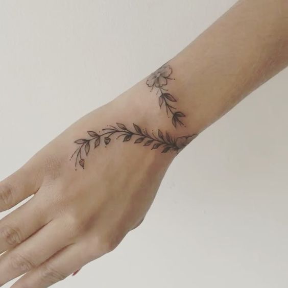 Tatuaje de Brazalete o Pulsera tipo enredadera hasta la mano y con una flor