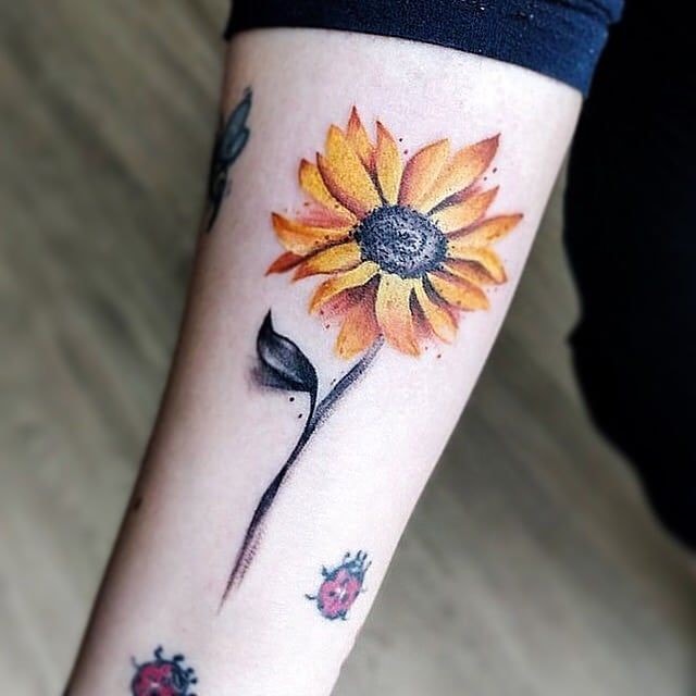 Tatuaggio di girasole sul braccio con coccinelle 3 4