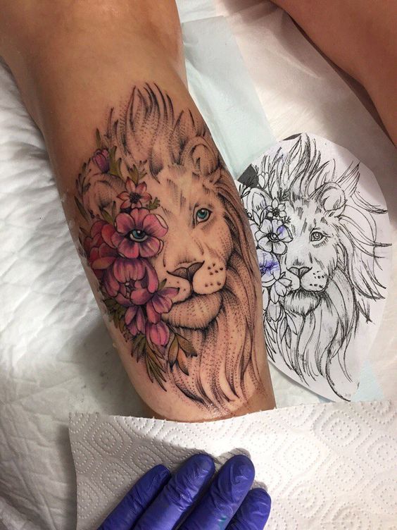 Tatuaje de Leon con ojos con flores rojas