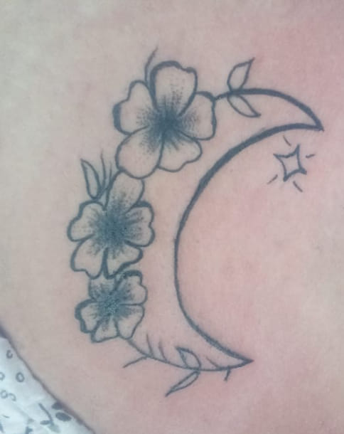 Luna con tatuaggio di stelle e fiori