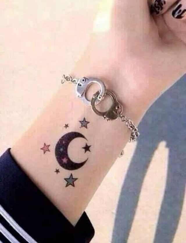 Moon tattoo with small stars on wrist