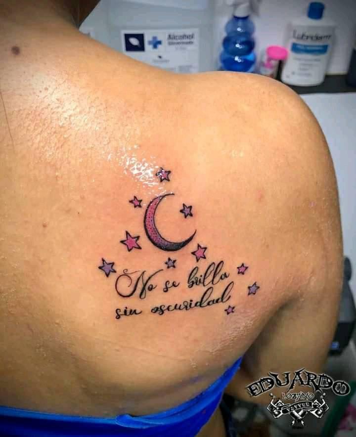 Tatuaje de Luna y estrellas en omoplato y frase No se brilla en la obscuridad