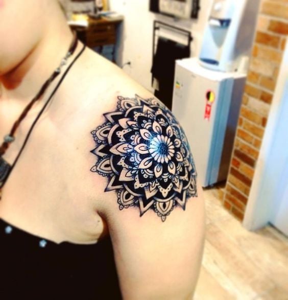 Glänzendes schwarzes Mandala-Tattoo auf der Schulter