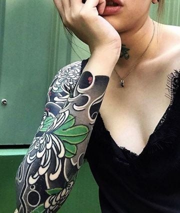 Sleeve Tattoo With Green Colors in Leaves and Red Details