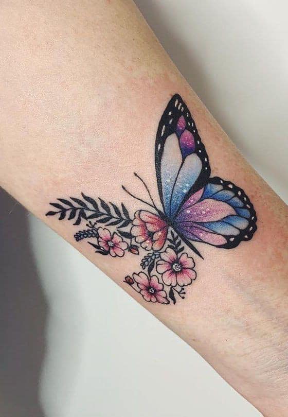 Tatuaggio di farfalla sull'avambraccio, un'ala di fiori e un'ala blu e viola