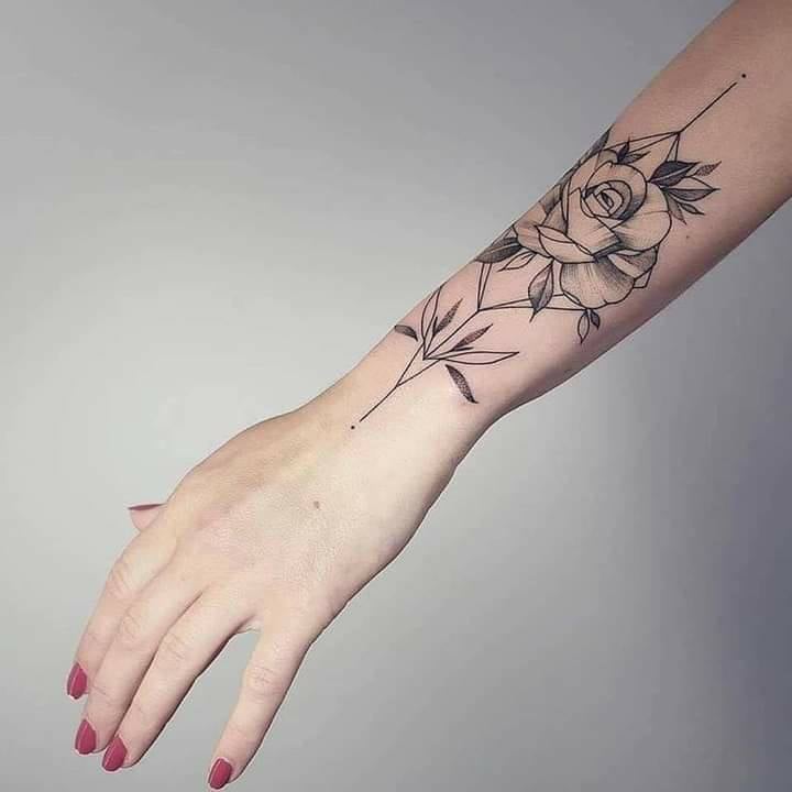 Black rose tattoo on forearm