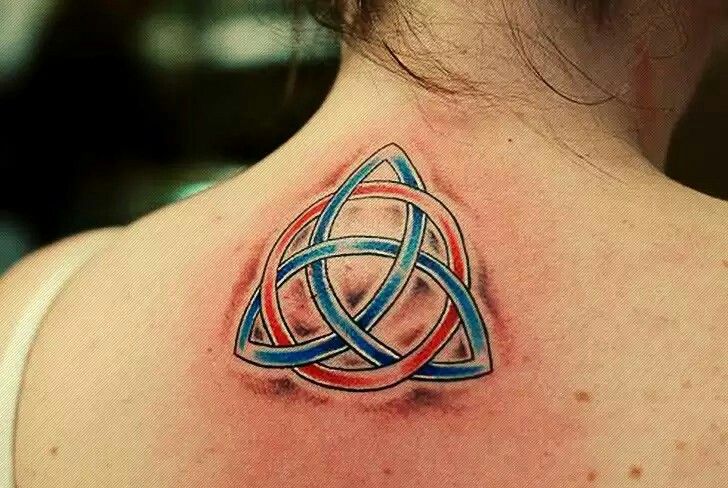Tatuaje de Simbolo Celta de Triqueta entre los omoplatos con circulo rojo