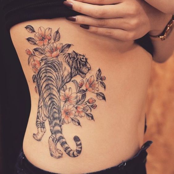 Tatuaje de Tigre con flores en costilla