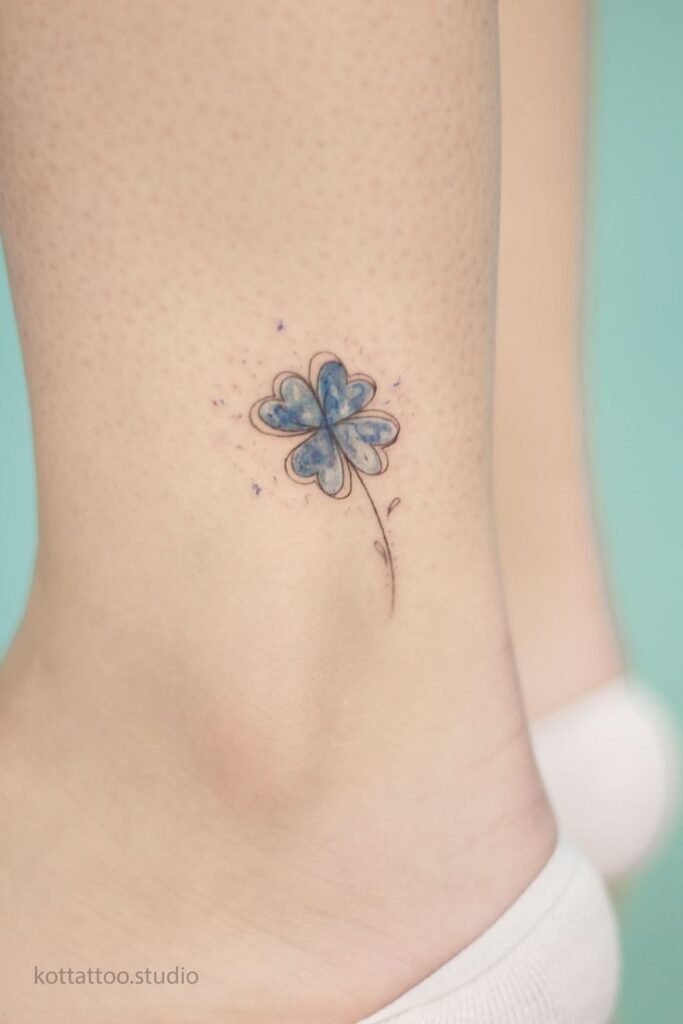 Tatuaje de Trebol pequeno azul en pantorrilla