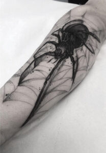 Spider tattoo on a man's arm meaning
