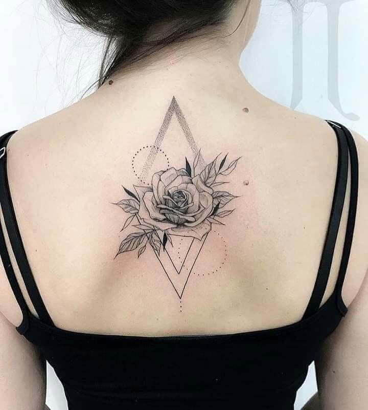 Tatuaggio con rose e rombi sulla schiena di una donna