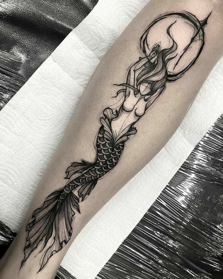 Tatuagem de sereia tipo desenho com círculo atrás da cabeça