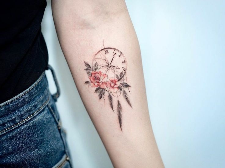 Tatuaje delicado de flores y reloj en el brazo