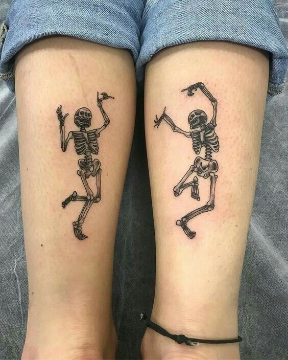 Tatouage jumelé de deux squelettes, un sur chaque avant-bras