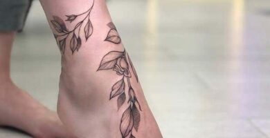 Tatuaje empeine mujer delicada rama y flores rodeando pie 40