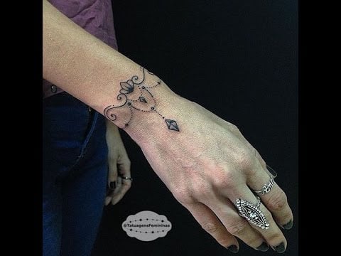 Ciondolo e braccialetto tipo Dreamcatcher tatuaggio sul polso di una donna