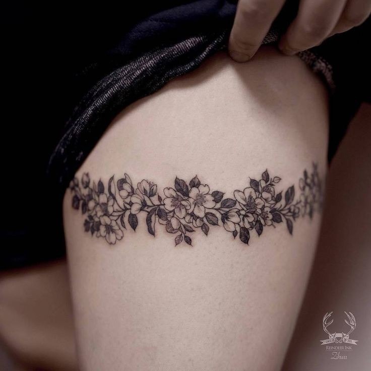 Tatuaje en Muslo de Mujer Trenza o liguero de ramas de flores negras