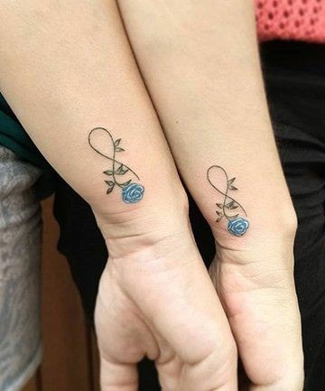 Tattoo auf dem Unterarm verbindet blaue Blume und Unendlichkeit