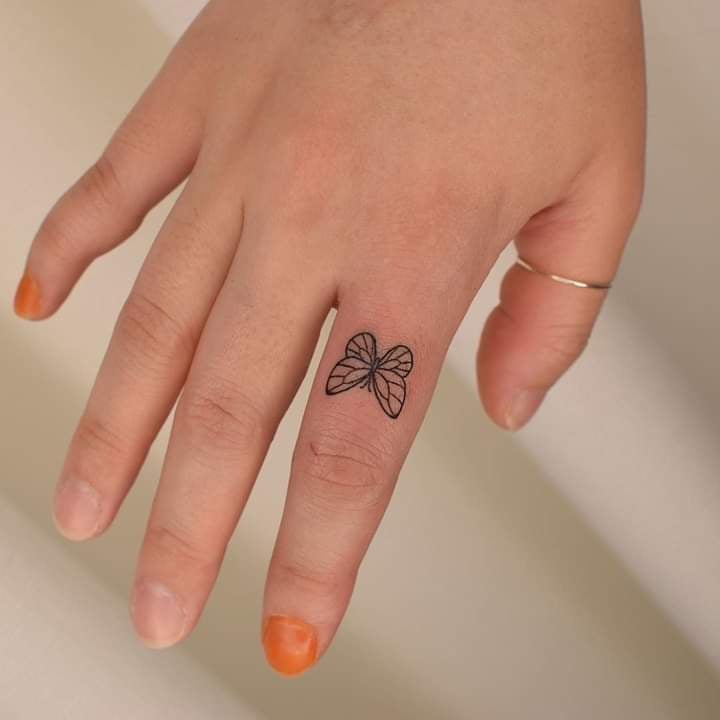 Butterfly tattoo on index finger