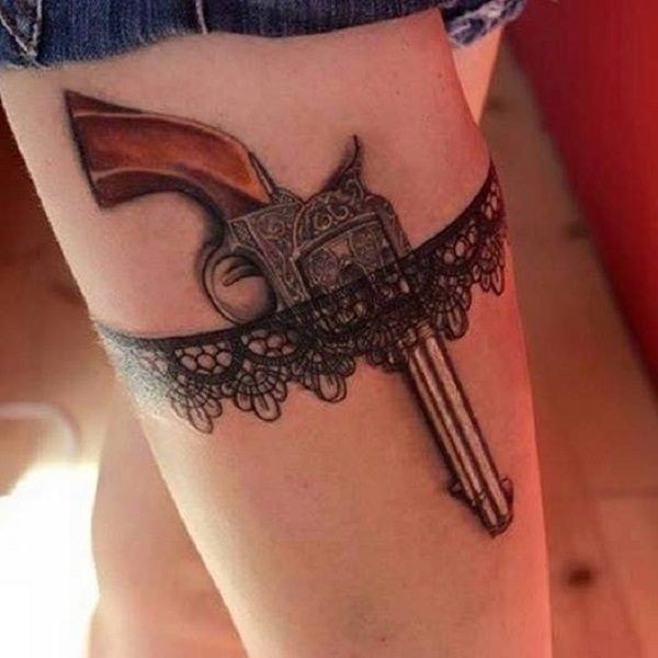 Tattoo on leg of woman garter belt with gun
