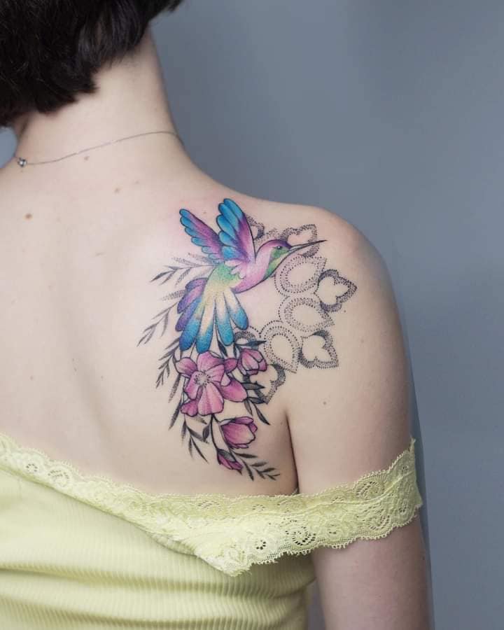 Simpatico tatuaggio di colibrì e fiori per donna in blu e viola
