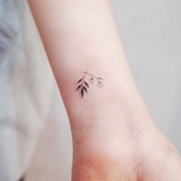Bellissimi piccoli tatuaggi per donne, minuscolo ramoscello nero sul polso