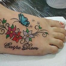 Lindas tatuagens para mulheres borboleta azul e flores vermelhas e brancas a pé