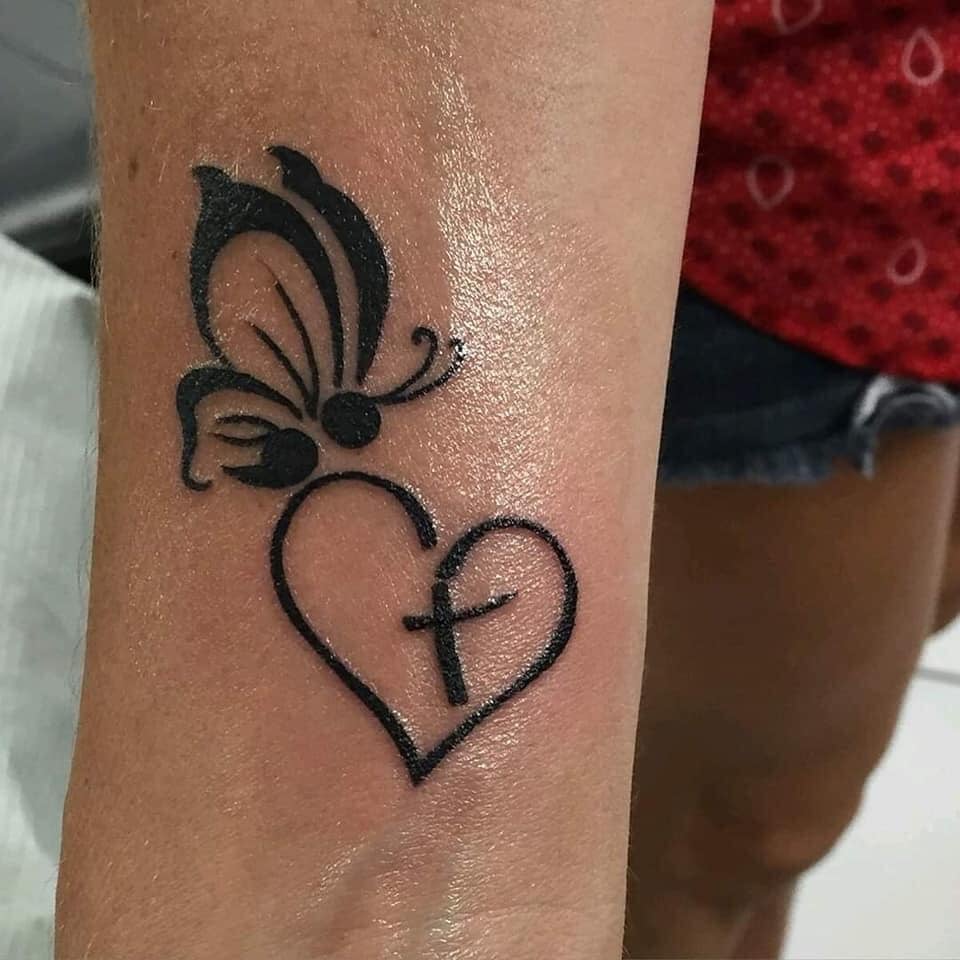 Schöne Tattoos für Frauen Herz mit Kreuz und schwarzem Schmetterling