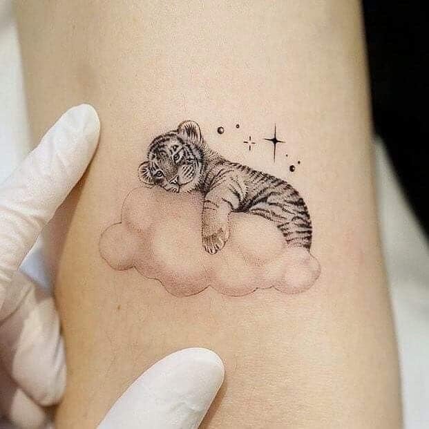 Belas tatuagens para mulheres Tigre deitado em uma nuvem e estrelas