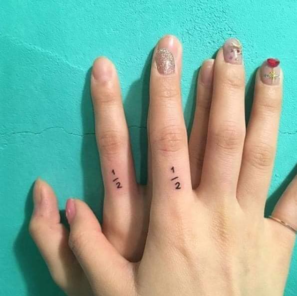 Piccoli tatuaggi per donne raffinati abbinati alle dita con l'iscrizione di un mezzo
