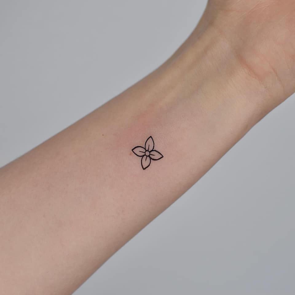 Super kleine minimalistische Tattoos mit Umriss einer vierblättrigen Blume am Handgelenk