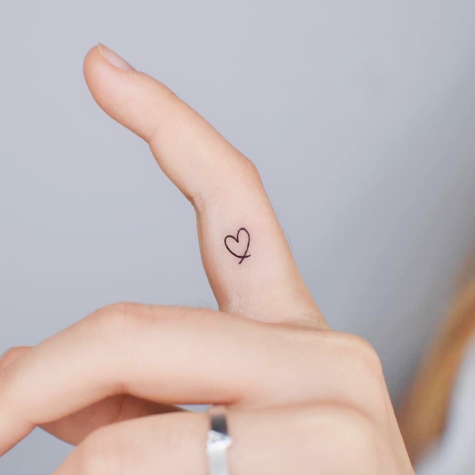 Tatuagens de coração superpequenas e minimalistas no dedo indicador