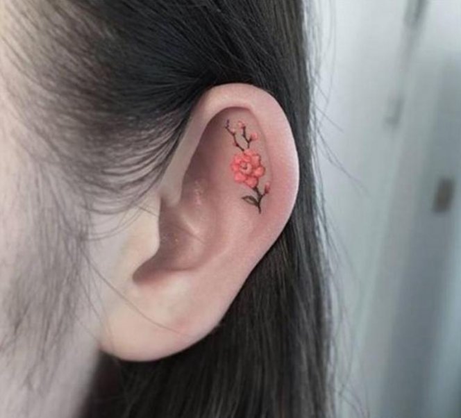 Small orange flower ears tattoos