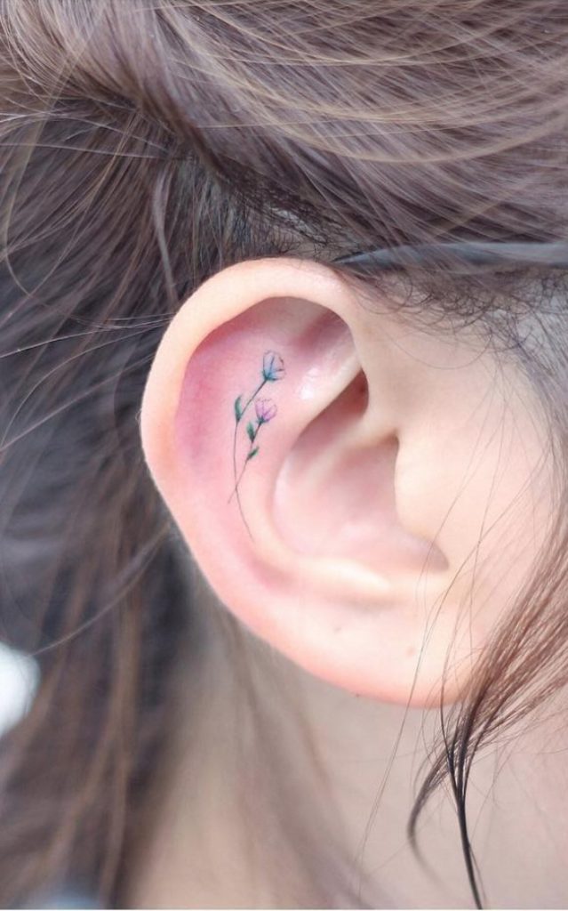 Tiny pink flower ears tattoos