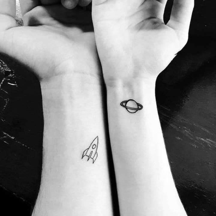 Piccoli tatuaggi per coppie razzo e Saturno sui polsi